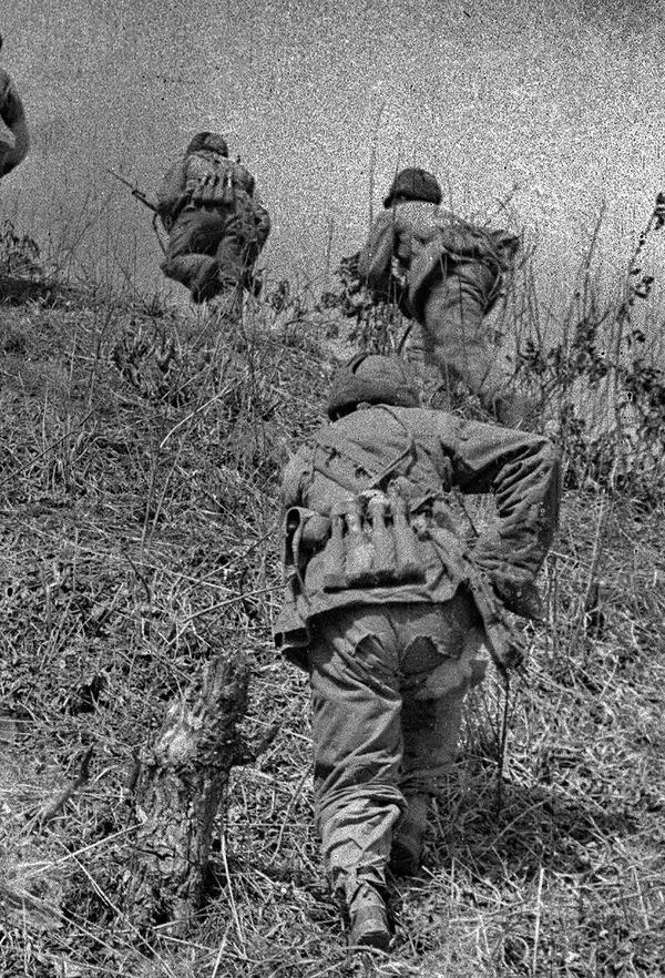 1951年4月，志愿军指战员在缺衣少食缺弹药的艰苦条件下英勇奋战。正在向山上冲击的战士军裤上有两个大洞。 张崇岫 摄