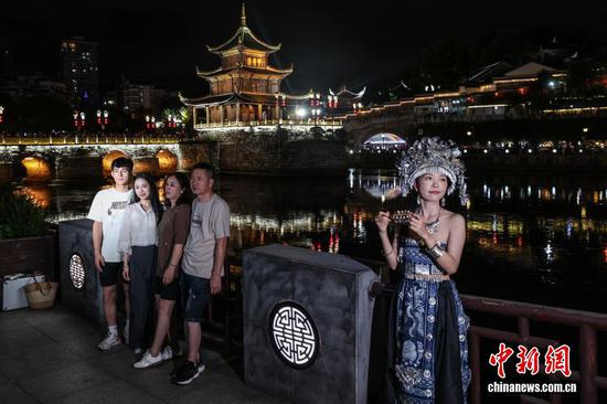 图为游客在甲秀楼景区打卡拍照。