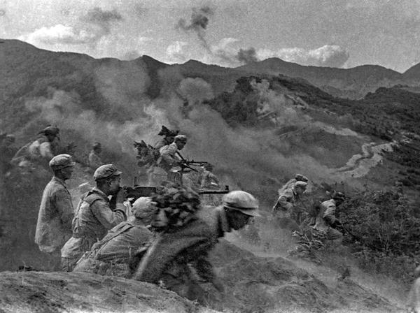 1951年4月22日，第五次战役，志愿军第9兵团下属20军、26军、27军突破美军防御，越过“三八线”向南进攻。图为战士们在炮火连天的战场上英勇奋战的瞬间。   张崇岫 摄