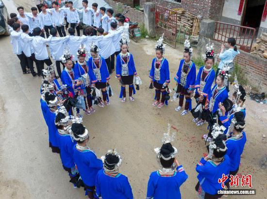 图为顶洞村的侗族少男少女在路上对唱侗歌。(无人机照片)吴德军 摄