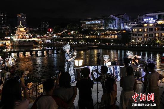 图为游客在甲秀楼景区穿着民族服装拍摄写真。