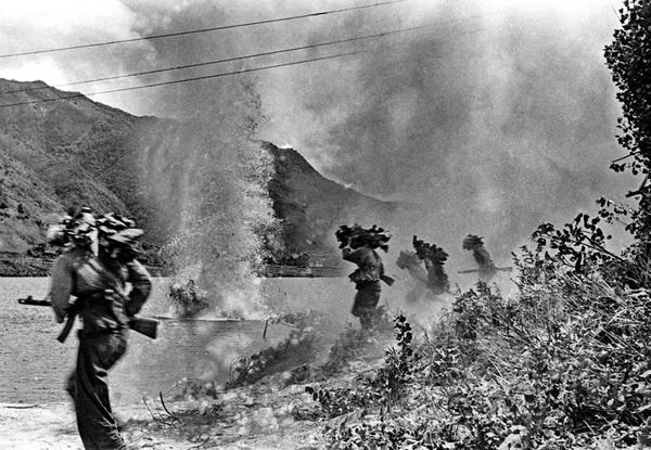 1951年5月16日下午5时40分后，志愿军第20军60师178团3营8连指战员冒着敌人的炮火强渡昭阳江。炮弹炸起的水柱根部左侧，一战士被炮弹炸倒。 张崇岫 摄