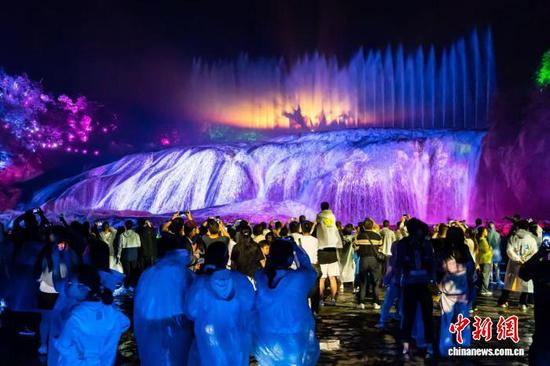 7月28日晚,游客在贵州黄果树景区陡坡塘瀑布观看大型实景仙幻剧《再回西游》。(黄果树景区供图) 7月28日晚,游客在贵州黄果树景区陡坡塘瀑布观看大型实景仙幻剧《再回西游》。(黄果树景区供图)