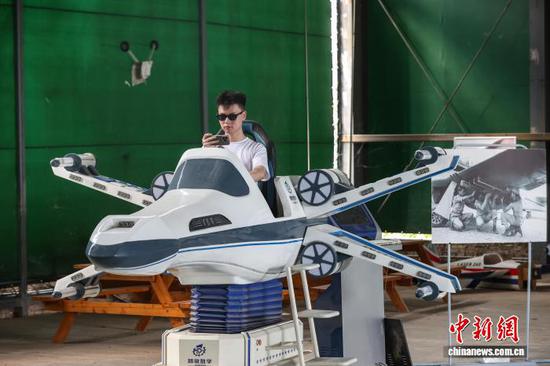 8月10日，游客在黄平旧州机场航空文化展示区体验飞行娱乐设备。中新社记者 瞿宏伦 摄