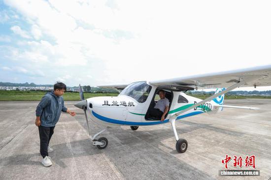 8月10日，飞行教员金明松在黄平旧州机场检查航空器。中新社记者 瞿宏伦 摄