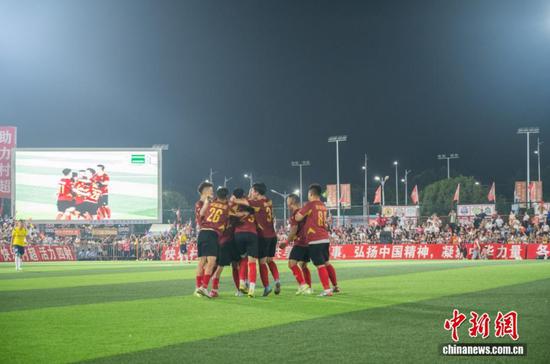 图为忠诚村足球队在场上相拥庆祝获得总决赛冠军。