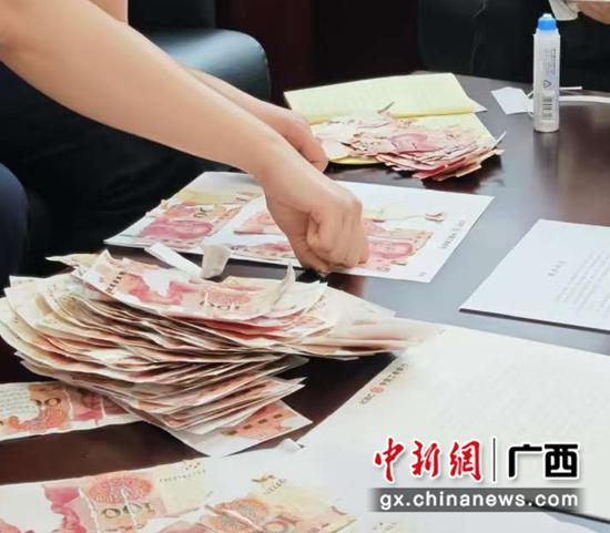 工商银行柳州市铁路支行工作人员为客户清点鉴别残损币。 工商银行柳州市铁路支行工作人员为客户清点鉴别残损币。