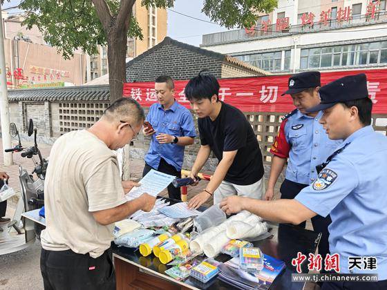 图为北京铁路公安局天津公安处唐山北站派出所民警会同车站工作人员宣传爱路护路安全常识，图中民警正向社区居民分发传单。（北京铁路公安局天津公安处供图）