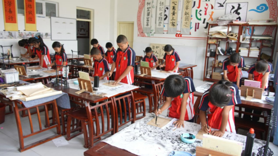 洛浦县第一小学学生习练书法。