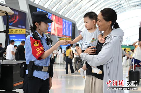 图为北京铁路公安局天津公安处天津西站派出所民警与旅客友好互动。（北京铁路公安局天津公安处供图）