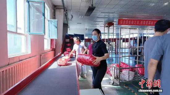 8月12日，新疆呼图壁县电子商务科技产业园仓储物流中心内，工作人员正将新打包的包裹放上传送带。刘远 摄