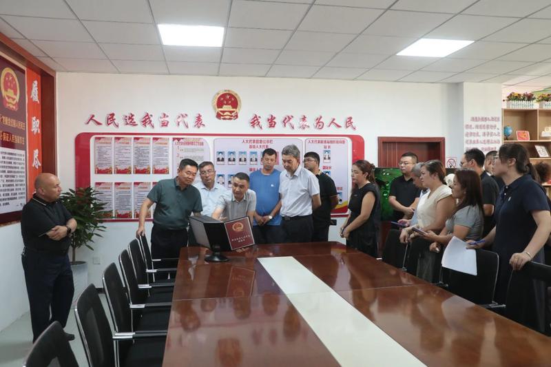 上图：与会人员在托克扎克镇新区社区人大代表联络站现场观摩。