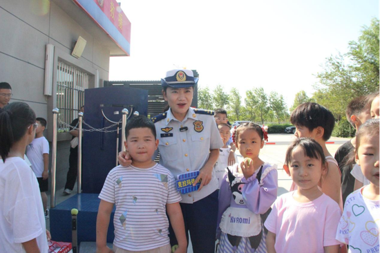 图为宣传员和参加活动的学生互动e