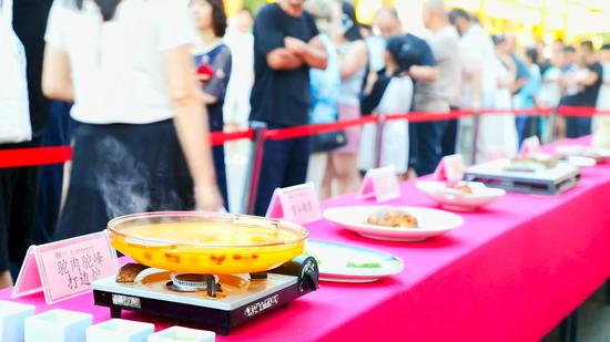 驼肉驼峰打边炉等特色菜已经准备完毕,市民正排队准备品尝。杨涛 摄