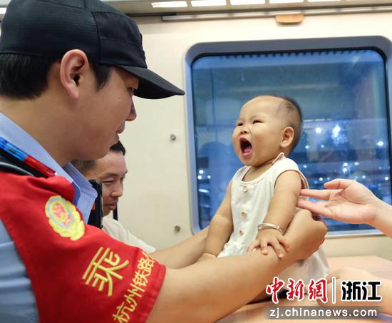 图为:乘警照看幼小旅客。中新社发 贺瑞明 摄