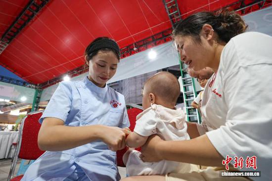 图为医护人员为孩童推拿。中新社记者 瞿宏伦 摄