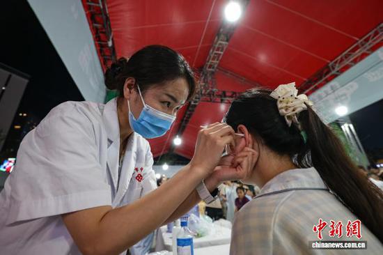 图为医护人员为市民耳灸。中新社记者 瞿宏伦 摄