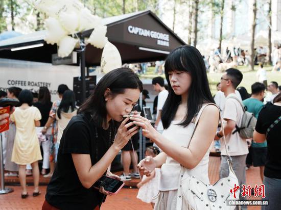 8月17日，贵州省贵阳市观山湖区，民众在咖啡集市上品尝购买的咖啡。中新社记者 周燕玲 摄