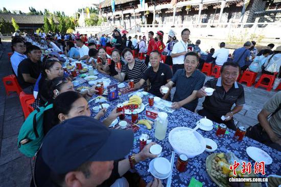 图为游客在品尝长桌宴。   何志刚 摄