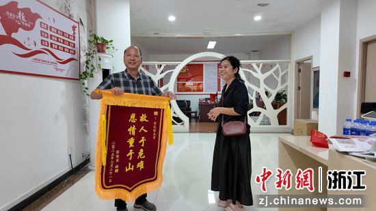 张俊英将锦旗送到余礼旺手中。淳安县委宣传部 供图 张俊英将锦旗送到余礼旺手中。淳安县委宣传部 供图