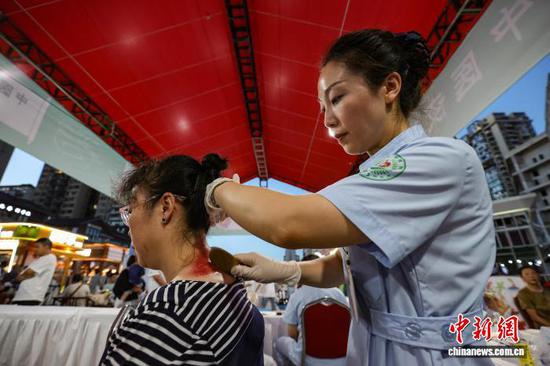 图为医护人员为市民刮痧。中新社记者 瞿宏伦 摄