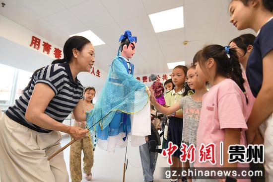 8月18日，在贵阳市南明区文化馆暑期未成年人文艺培训班，木偶老师让木偶与小朋友们进行互动。