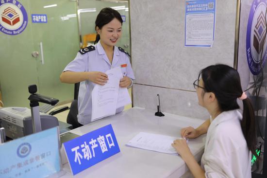 为深化高效办成一件事改革，织金县税务局打造”不动产专窗“，联合自然资源、住建部门推行“联合咨询、综合收件、统一发证”一窗办服务。图为不动产专窗税务人员为办税人讲解业务办理资料情况。高莉佳摄