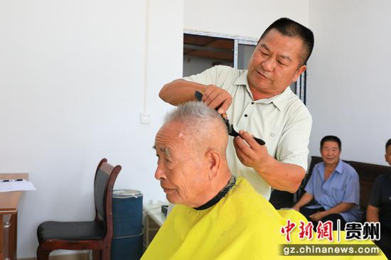 理发师正在为老人理发。钟成炫 摄 理发师正在为老人理发。钟成炫 摄