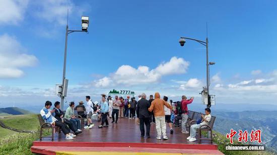 日前,贵州省赫章县阿西里西·韭菜坪景区十余万亩野生韭菜花竞相绽放,形成绚烂的紫色花海,吸引了各地游客前来观赏。漫山遍野的紫色花朵与不远处的风车、山峰、蓝天和白云相互映衬,构成了一幅美丽的画卷。图为8月27日,游客在大韭菜坪景区海拔2777米处旅游观光 。 盛灿 摄 日前,贵州省赫章县阿西里西·韭菜坪景区十余万亩野生韭菜花竞相绽放,形成绚烂的紫色花海,吸引了各地游客前来观赏。漫山遍野的紫色花朵与不远处的风车、山峰、蓝天和白云相互映衬,构成了一幅美丽的画卷。图为8月27日,游客在大韭菜坪景区海拔2777米处旅游观光 。 盛灿 摄