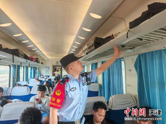图为北京铁路公安局天津公安处乘警支队民警韩士龙在列车上开展巡逻巡视并检查列车重点部位。（北京铁路公安局天津公安处供图）