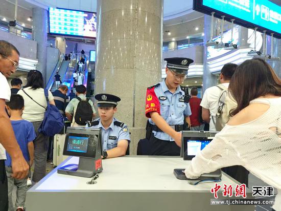图为北京铁路公安局天津公安处民警在进站口开展核查工作，坚决确保车站安全。（北京铁路公安局天津公安处供图）