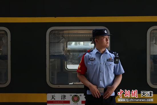 图为北京铁路公安局天津公安处乘警支队民警韩士龙在列车开车前立岗巡视。（北京铁路公安局天津公安处供图）