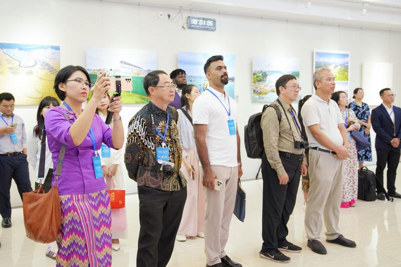 东盟媒体代表在广西云发布厅举起手机拍摄“2025中国—东盟青年春日联欢会”视频。