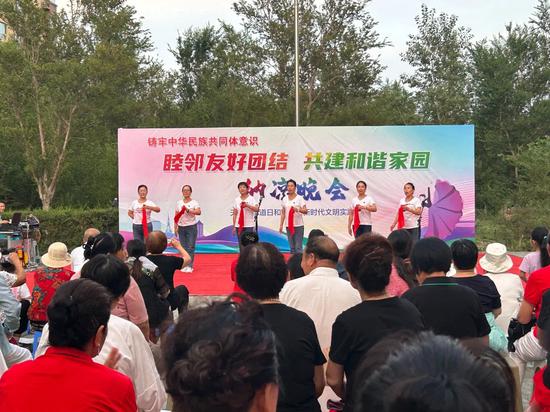 日和园社区“和润之声”宣讲队在社区纳凉晚会上进行快板宣讲。