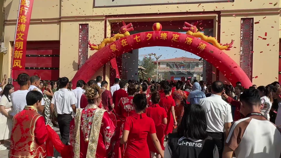 人群经 “爱在七夕・缘定洛浦” 拱门涌入,彩屑纷飞。