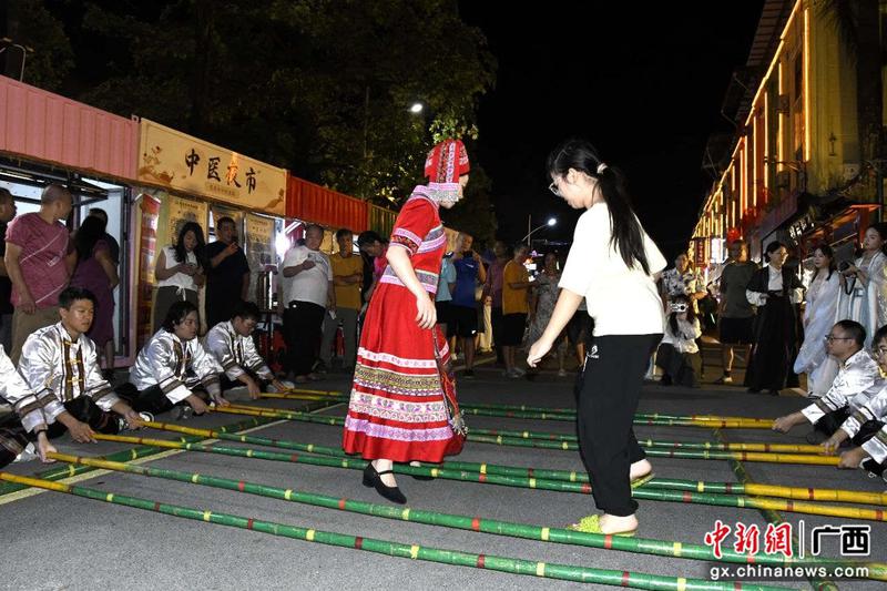 图为游客体验竹竿舞。 图为游客体验竹竿舞。