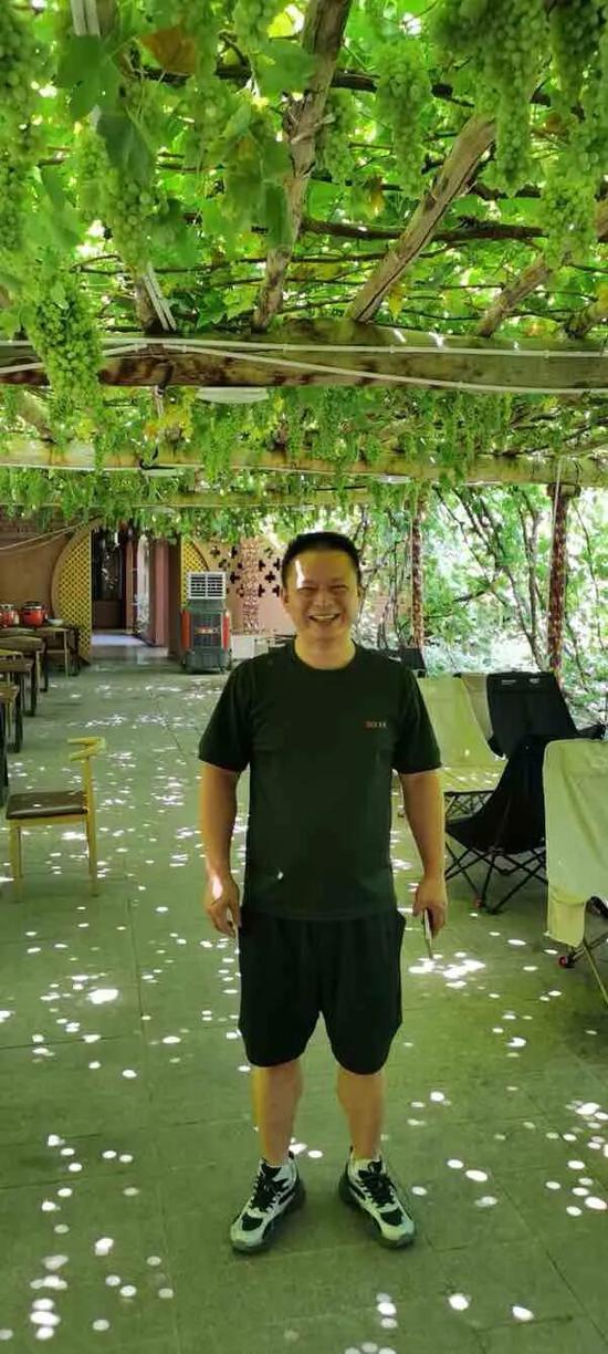 张凯在民宿葡萄架下。胡真、黄珀摄c