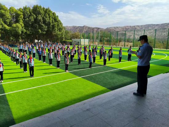 图四:8月27日,哈密公安处吐鲁番北站派出所民警在布依鲁克小学开展“开学第一课”普法宣传教育
