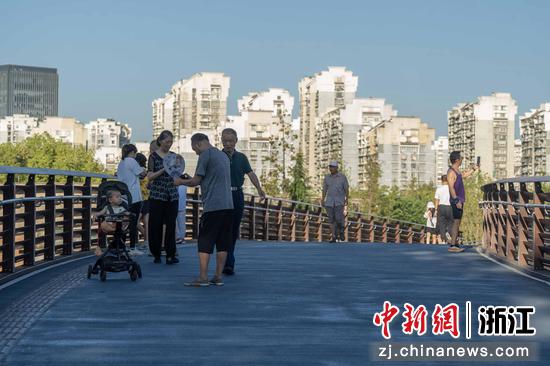 8月28日，民众在人行桥上行走。（杭州市商旅运河集团供图）