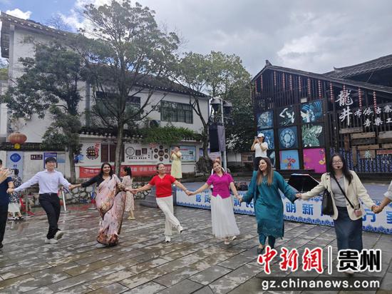 在贵阳市花溪区龙井村，代表团成员与游客、当地村民手拉手跳起团圆舞。