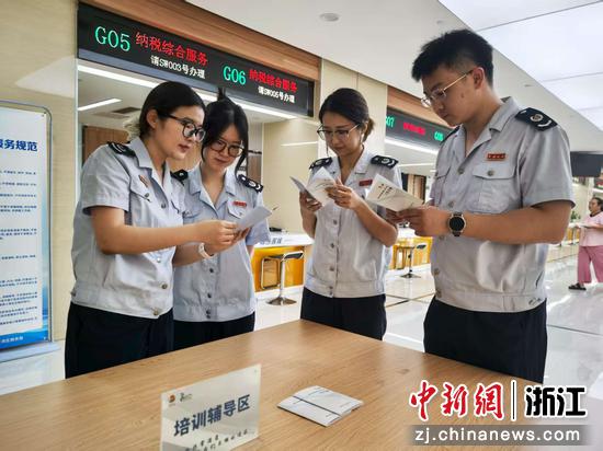 窗口工作人员阅读《手册》。高杨晔 供图 窗口工作人员阅读《手册》。高杨晔 供图