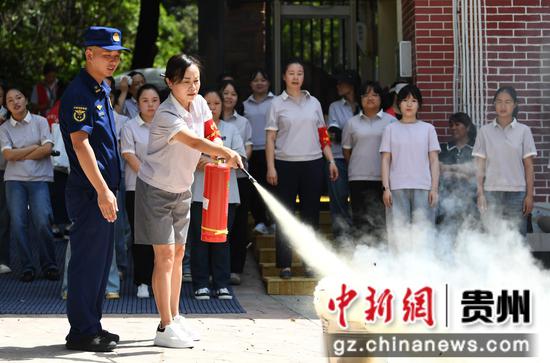 9月1日，在贵阳市南明实验幼儿园，消防员指导幼儿园老师使用灭火器灭火。
