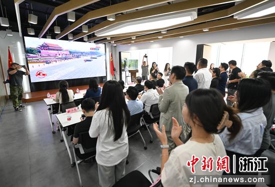 图为:浙江杭州,港澳青年等在湖滨商圈观看阅兵并热烈鼓掌。中新社记者 王刚 摄