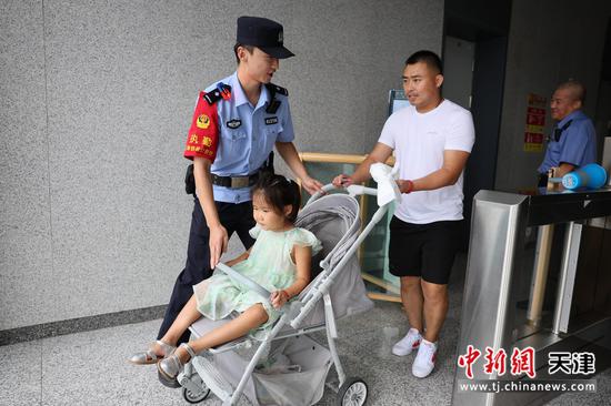图为北京铁路公安局天津公安处燕郊站派出所民警在闸机口帮助带小孩的旅客进站乘车。（北京铁路公安局天津公安处供图）