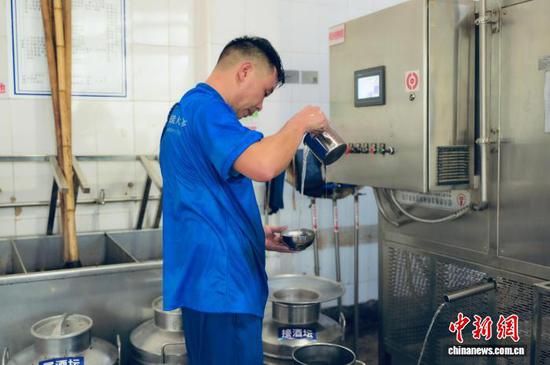 图为参赛选手在仔细查看酒液。胡大方 摄