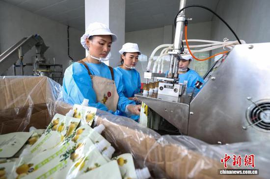 9月11日，工人在龙里县谷脚镇一家刺梨加工工坊灌装刺梨原液。