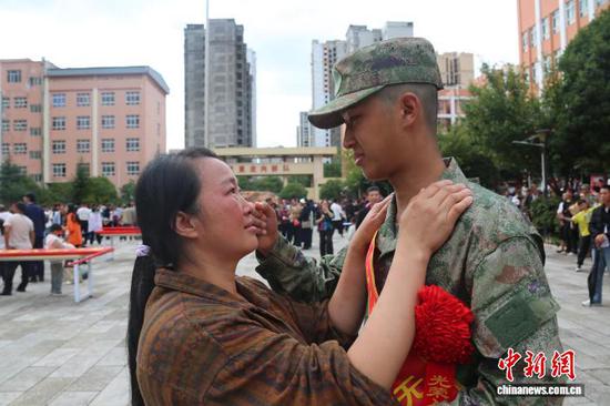 图为9月13日，威宁彝族回族苗族自治县入伍新兵向家属告别。赵庆能 摄