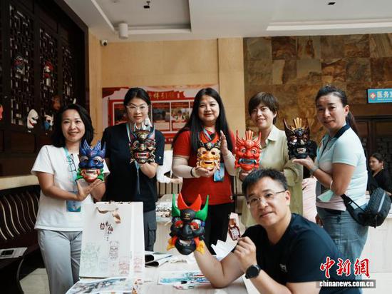 图为台湾青年在贵州傩文化博物馆体验绘制傩面具并进行展示。中新网记者 周燕玲 摄