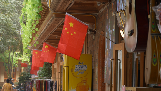 和田市团城景区商户在门前挂上国旗。5