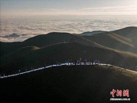 图为游客在贵州省毕节市赫章县韭菜坪景区旅游观景。